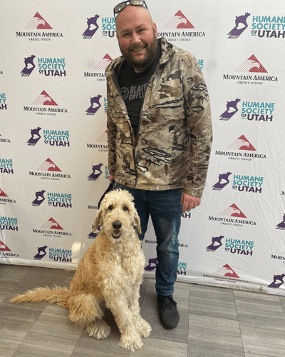 A man poses with newly adopted dog during Fall in Love Adoption Event. 