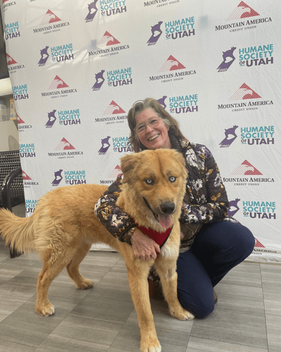 A middle aged woman poses with newly adopted dog during Fall in Love Adoption Event. 